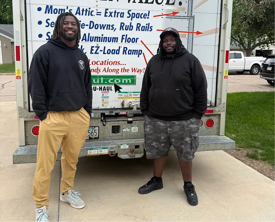 Next Move Madison movers unloading a branded moving truck in front of a Madison home, with the Wisconsin State Capitol in the background
