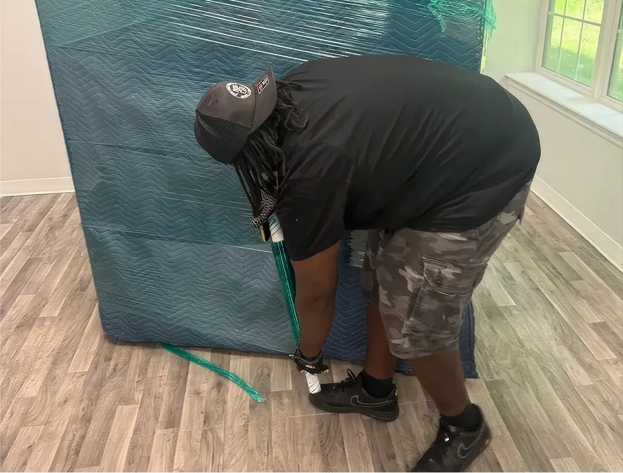 Movers loading a moving truck with wrapped furniture