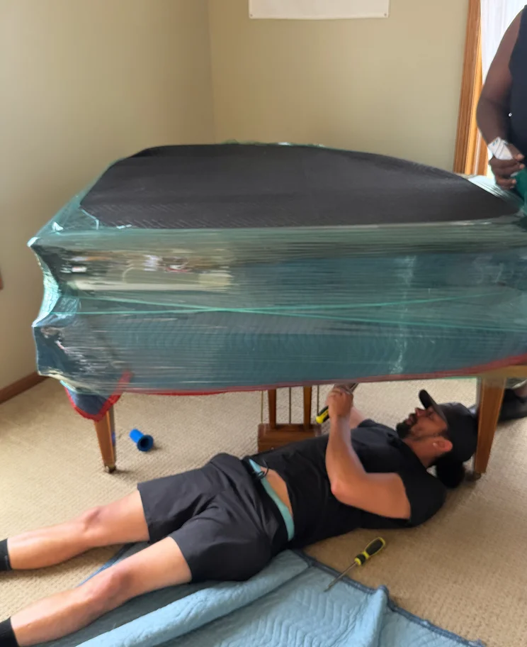 Two movers carrying a couch to a moving truck